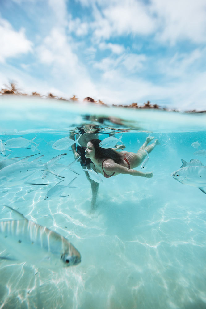 Femme qui nage au milieu des poissons