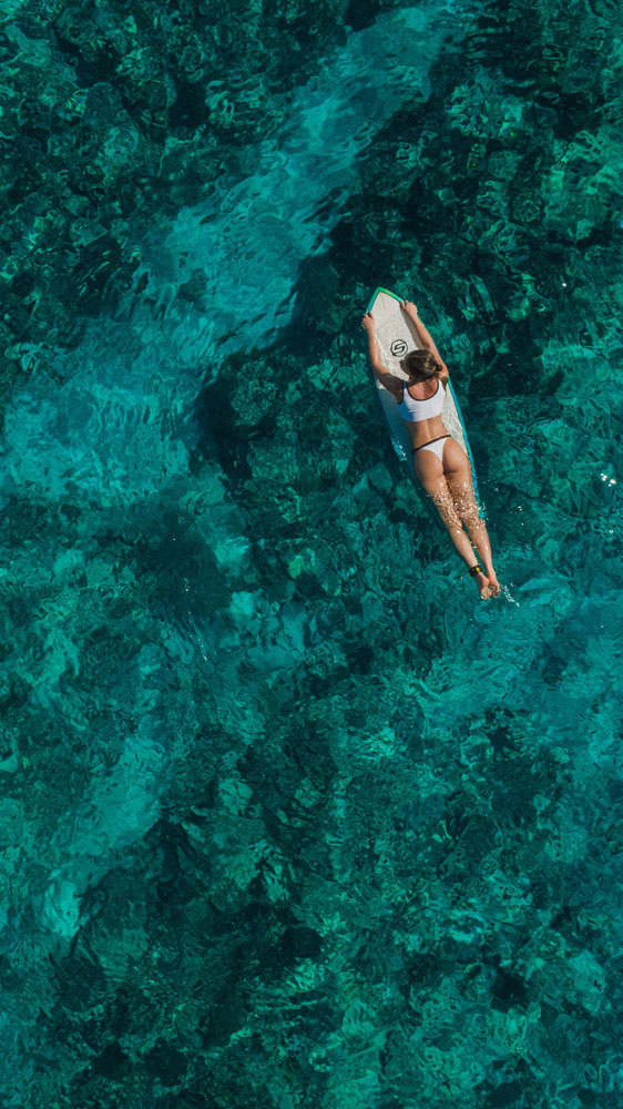 Femme sur une planche de surf au milieu de l'océan